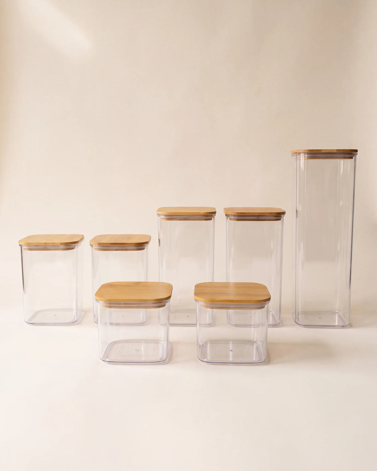 Set organizador de alimentos con tapa de bambú x7 Vibento, siete recipientes herméticos transparentes sobre fondo crema